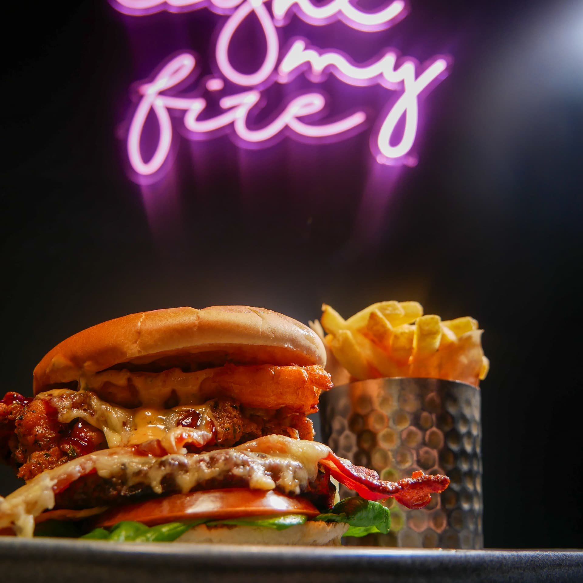 Charbox stacked burger shot under neon signage