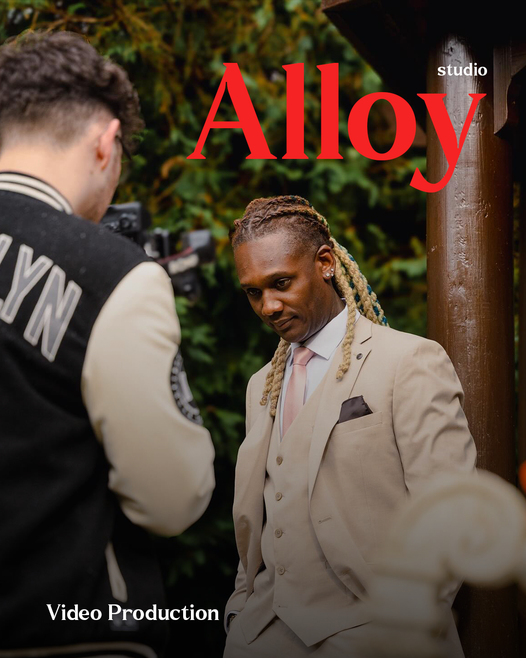 Behind the scenes of an Alloy studio video shoot with a camera operator filming talent in a suit